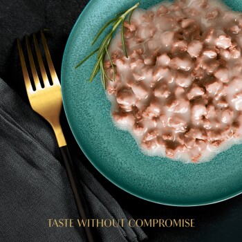 A teal plate with wet pet food and rosemary, next to a gold fork and dark napkin. Text: "TASTE WITHOUT COMPROMISE."