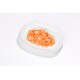 Nourriture humide pour animaux au saumon émiettée sur une assiette ovale blanche sur fond blanc.