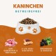 Weiße Schüssel mit Hundefutter mit Pfotenabdrücken, beschriftet "KANINCHEN GETREIDEFREI", enthält 50% Kaninchen & Truthahn, 21,5% Süßkartoffeln, Brombeeren, Kräuter.