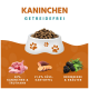 Weiße Schüssel mit Hundefutter mit Pfotenabdrücken, beschriftet "KANINCHEN GETREIDEFREI", enthält 50% Kaninchen & Truthahn, 21,5% Süßkartoffeln, Brombeeren, Kräuter.