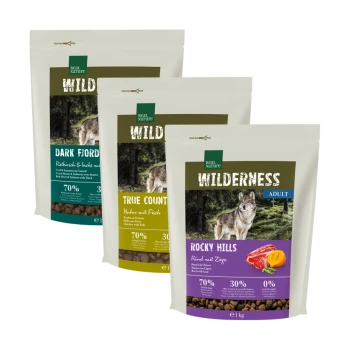 Drei Säcke von Real Nature's "Wilderness" Hundefutter: "Dark Fjord", "True Country" und "Rocky Hills", mit Wolf-Bildern und Nährwertinformationen.