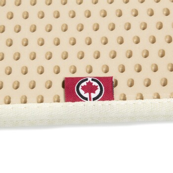 Nahaufnahme einer beigen Haustiermatte mit einer strukturierten Oberfläche mit kleinen Erhebungen und einem roten Etikett mit einem weißen Ahornblatt-Logo.