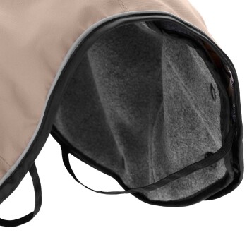 Nahaufnahme des Innenraums eines beigen Haustiermantels, der weiche graue Fütterung und schwarze Riemen für eine sichere Befestigung zeigt.