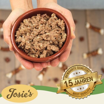 Eine Person hält eine braune Schüssel mit Haustierfutter, mit einem Abzeichen, das 'Beste Qualität' und '15 Jahre' auf Deutsch angibt, was 15 Jahre Qualität bedeutet.