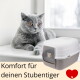 Graue Katze liegt neben einem weißen geschlossenen Katzenklo; Text 'Komfort für deinen Stubentiger' und rotes Herz mit Pfote.
