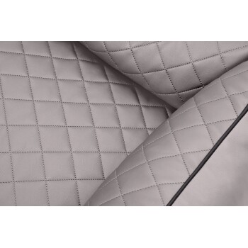 Nahaufnahme eines weichen, gesteppten Haustierbettes in hellgrau, mit einem Diamantmuster und kontrastierenden Nähten.