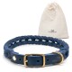 Ein geflochtener blauer Lederhalsband für Hunde mit einer Messing-Schnalle, begleitet von einem beigen Zugbeutel mit dem Logo "Freudentier."
