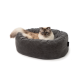 Langhaarige blauäugige Katze, die in einem runden grauen Cord-Katzenbett liegt, mit kleinem schwarzem Etikett mit weißer Aufschrift.