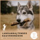 Ein wolfähnlicher Hund hält einen Kauknochen, mit verschwommenem Hintergrund im Freien und Text: "LANGANHALTENDES KAUVERGÜNGEN" und "natürlich & kalorienfrei."