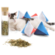 Eine entspannte Katze liegt neben bunten, dreieckigen Katzenminze-Spielzeugen und einem Glasbehälter, der mit getrockneten Katzenminzblättern gefüllt ist.
