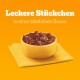 Schüssel mit Haustierfutter mit Stücken in einer herzhaften Sauce, mit Erbsen und roten Paprika, auf einer gelben Serviette vor einem orangefarbenen Hintergrund.