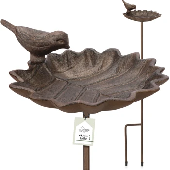 Ein dekorativer Vogelbad mit einer blattförmigen Schale und einer kleinen Vogelskulptur, die auf der Kante sitzt, 68,5 cm hoch.