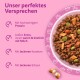Schüssel mit Trockenfutter auf rosa Hintergrund mit Text ‚Unser perfektes Versprechen‘ — hoher Proteingehalt; knusprige Hülle, milchig weicher Kern; Karotten & Erbsen