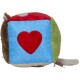Buntes Plüschtier in Würfelform, mit einem roten Herzen auf einer blauen Seite, mit grünen und braunen Akzenten.