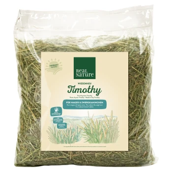 A clear bag of green Timothy hay labeled "Real Nature Timothy," suitable for small animals and dwarf rabbits in multiple languages.