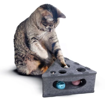 Eine verspielte getigerte Katze interagiert mit einer dreieckigen Filzspielzeugbox mit Löchern und bunten Bällen darin, die Engagement und Spaß fördert.
