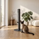 Eine schwarze Katze, die einen hohen, weißen Kratzbaum erklimmt, mit ihren Vorderpfoten, die den Baum greifen, und ihrem Schwanz, der herunterhängt.