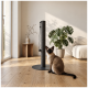Eine schwarze Katze, die einen hohen, weißen Kratzbaum erklimmt, mit ihren Vorderpfoten, die den Baum greifen, und ihrem Schwanz, der herunterhängt.
