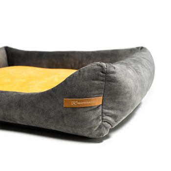 Graues Haustierbett mit einem gelben Kissen, mit einem Lederschild, das "Rex Products" liest.