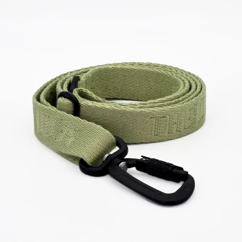 Hundeleine THE DOG IDEA Eine gerollte grüne Haustierleine mit einem schwarzen Karabinerclip, aus strukturiertem Stoff und dem Wort 'LEASH', das in den Riemen eingewebt ist.