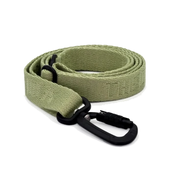 Eine gerollte grüne Haustierleine mit einem schwarzen Karabinerclip, aus strukturiertem Stoff und dem Wort 'LEASH', das in den Riemen eingewebt ist.