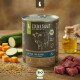 Dose LIEBESGUT Hundefutter mit Aufschrift "BIO-RIND FÜR WELPEN", Kuhskizze, Zucchini, Kürbiswürfel, Ölflasche und rohem Rindfleisch.