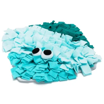 Eine flauschige, türkis- und aquafarbene Schnüffelmatte für Haustiere in Fischform, mit zwei großen schwarzen Augen und strukturierten Stoffstreifen zum Verstecken von Leckereien.