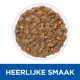 Natte huisdierenvoeding in een witte kom, met stukjes vlees en gesneden groenten, met de tekst 'HEERLIJKE SMAAK' eronder.