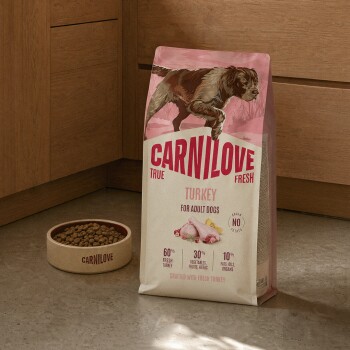 Sac d'aliments CARNILOVE dinde (True Fresh pour chiens adultes) à côté d'une gamelle de croquettes Carnilove.