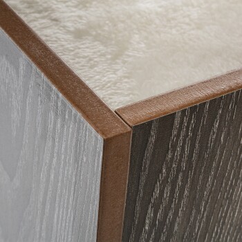 Nahaufnahme einer Ecke eines Haustierbettes mit einem weichen, plüschigen Innenraum und einem stilvollen zweifarbigen Holzfinish in Grau und Dunkelbraun.