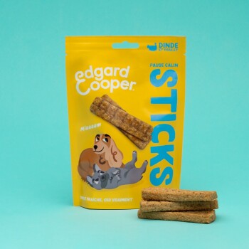 Emballage jaune de friandises pour chiens Edgard Cooper étiqueté "STICKS" avec des illustrations d'un chien et d'un chat, présentant quatre bâtonnets de friandises devant.