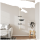 Ein moderner Katzenbaum mit einem weißen vertikalen Pfosten, drei dunkelgrauen Regalen und einer gemütlichen Schüssel, vor einer hellen Wand in einem stilvollen Wohnzimmer.