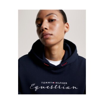 Eine Person trägt einen marineblauen Hoodie mit dem Text 'TOMMY HILFIGER Equestrian', der prominent auf der Vorderseite angezeigt wird.