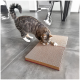 Getigerte Katze kratzt an einem zweiteiligen Karton-Kratzbrett auf grauem Fliesenboden in einem modernen Raum.