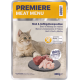 Eine hellbraune Katze sitzt neben einem Schieferplatte mit rohem Fleisch, mit einem Verpackungslabel, das 'Premiere Meat Menu' und 'Rind & Geflügel Medley' liest.