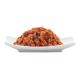 Ein Haufen Haustierfutter auf einem weißen Teller, der eine strukturierte, fleischige Mischung mit kleinen orangefarbenen Stücken zeigt, was auf zusätzliche Zutaten hindeutet.
