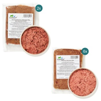 Verpackung für rohes Haustierfutter mit zwei 500g Packungen Rindfleisch und einer Schüssel mit Hackfleisch, gekennzeichnet mit 'Rind-Komplett Extra' und Nährwertangaben.