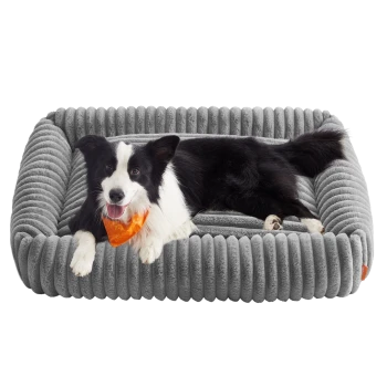 Schwarz-weißer Border Collie mit orangefarbener Bandana liegt auf einem grauen Plüsch-Haustierbett mit gerippter Struktur.