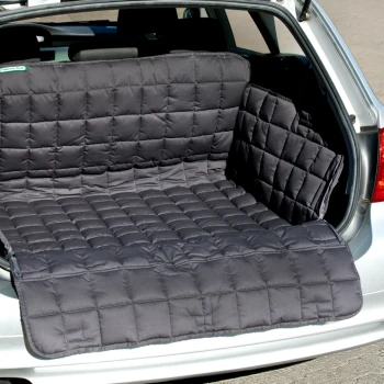 Ein schwarzer, gesteppten Autositzbezug für Haustiere liegt im Kofferraum eines silbernen Autos und bietet einen schützenden und komfortablen Platz für Haustiere.