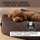 Nahaufnahme einer weichen, braunen Haustierdecke mit einem Etikett, das 'PAW MOM' liest. Text oben lautet 'HIMMELISCH WEICH – WIE AUF WOLKEN.'