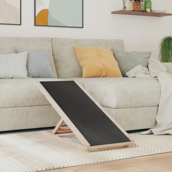 Eine hölzerne Haustierrampe mit schwarzer Oberfläche steht vor einem hellen Sofa, das mit bunten Kissen in einem gemütlichen Wohnzimmer dekoriert ist.