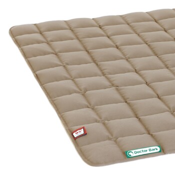 Eine beige Haustiermatte mit einem gesteppten Design, ausgestattet mit einem roten und weißen Etikett und einem grünen "Doctor Bark"-Logo.