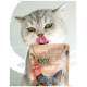 Zabawny kot liżący wargi przed paczką karmy dla kotów "CAT'S LOVE 100% Bio Adult", z obrazem szarego kota i etykietą "BIO RIND".