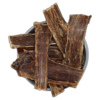 Getrocknete Rinder-Luftröhre Hundekauartikel gestapelt in einer grauen Schüssel auf weißem Hintergrund.