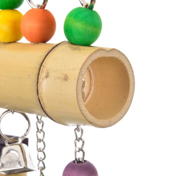 Bunte Holzperlen und eine Glocke hängen von einer Bambusstange, die ein für Vögel entworfenes Spielzeug zeigt.