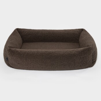Braunes, plüschiges Haustierbett mit erhöhten Rändern, entworfen für Komfort und Unterstützung, vor einem weißen Hintergrund.