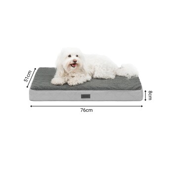 Ein gemütliches graues Hundebett mit den Abmessungen 76 cm x 57 cm x 8 cm, das eine weiche Oberfläche bietet und ein Haustier, das bequem darauf ruht.