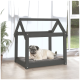 Ein Mops, der bequem auf einem grauen Kissen in einem stilvollen schwarzen Holzhaustierhaus liegt, mit großen Fenstern und einer Pflanze in der Nähe.