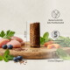 Ein zylindrisches Stück Haustierfutter (20-25 mm hoch, 10 mm Durchmesser) mit Symbolen, die einen hohen Fleischanteil und nährstoffreiche Superfoods zeigen.