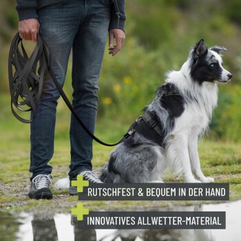 Person, die eine lange Leine hält, neben einem sitzenden schwarz-weißen Border Collie im Geschirr; deutscher Text über rutschfestes, allwettertaugliches Material